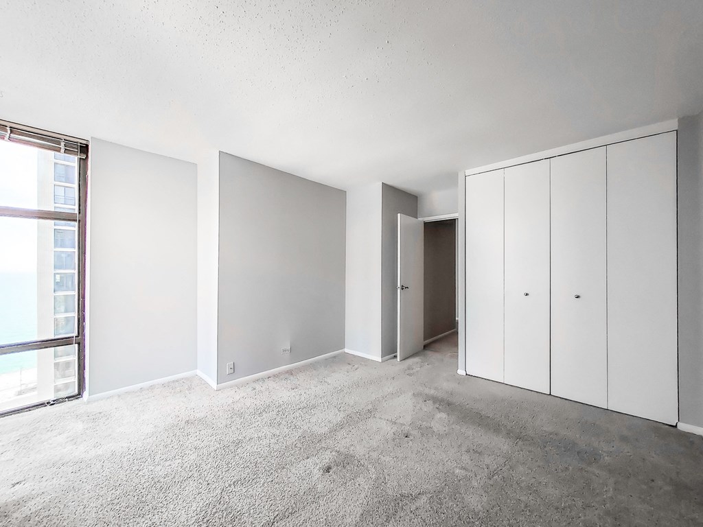 a bedroom with white walls and a concrete floor