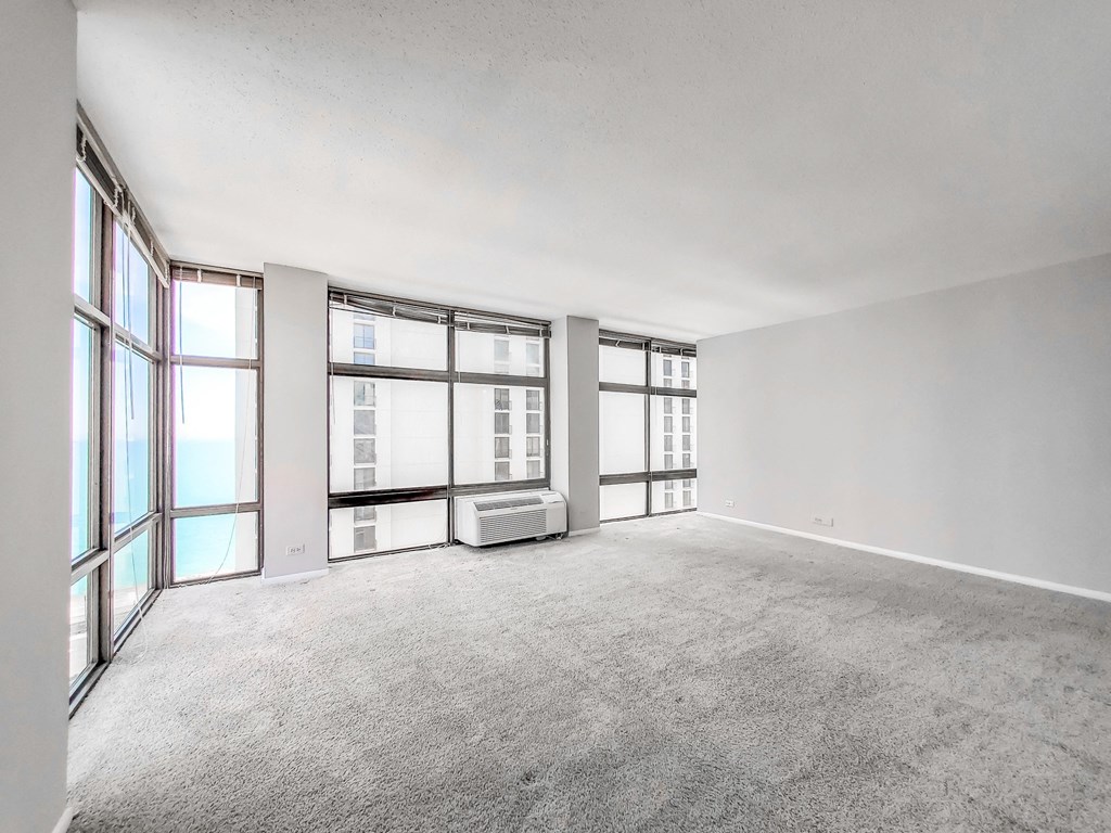 a bedroom with a large window and white walls
