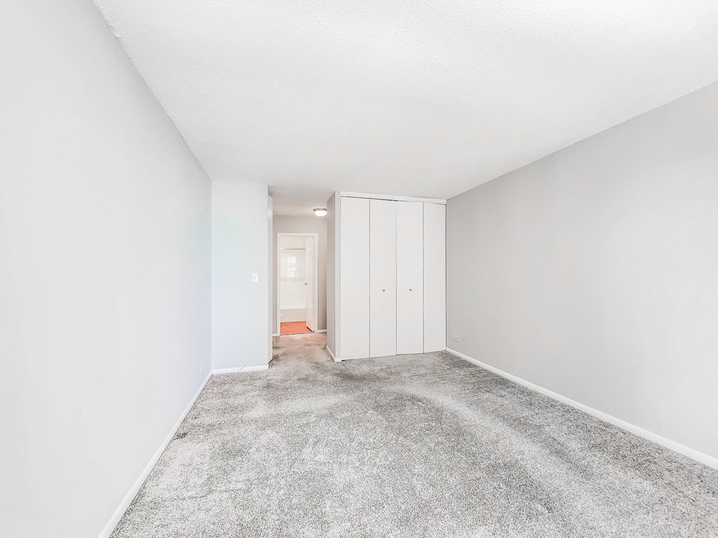 a bedroom with grey carpet and white walls