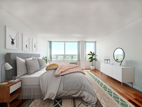 Bright bedroom at Presidential Apartments in Evanston, IL with queen bed, large windows, and hardwood floors.