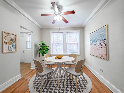 Park Shores Apartments in Buena Park Chicago dining room with round table, four chairs, ceiling fan, and hardwood floors.