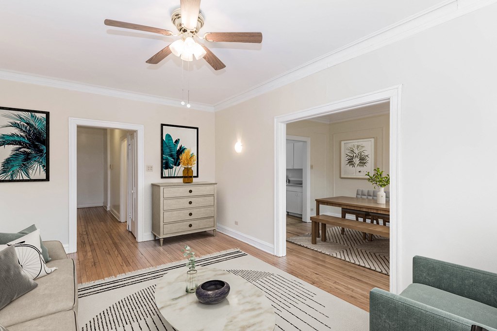 a living room with a ceiling fan and a dining room in the background