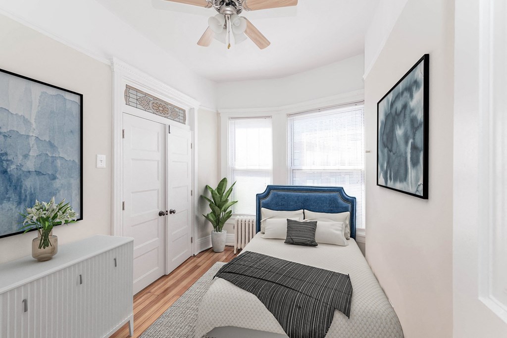a bedroom with a bed and a ceiling fan
