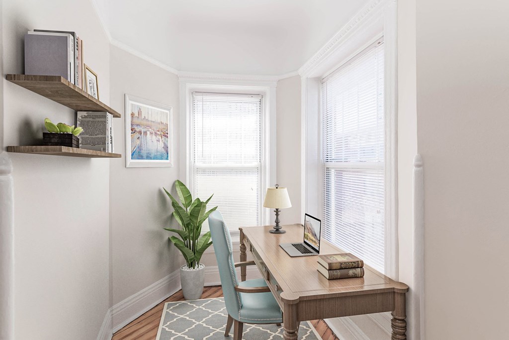 a home office with a desk and two windows