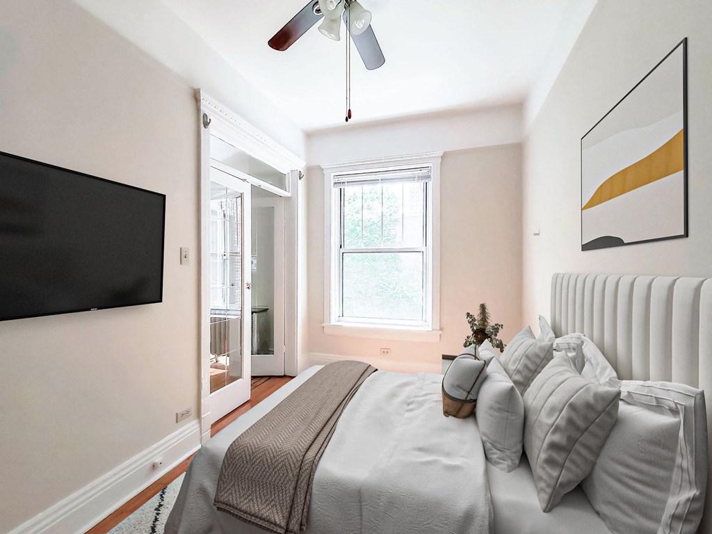 a bedroom with a large bed and a ceiling fan