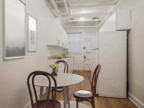a small kitchen with a white table and chairs