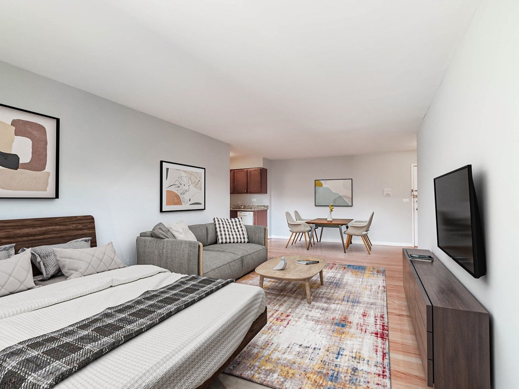 a bedroom with a bed and a couch in front of a tv