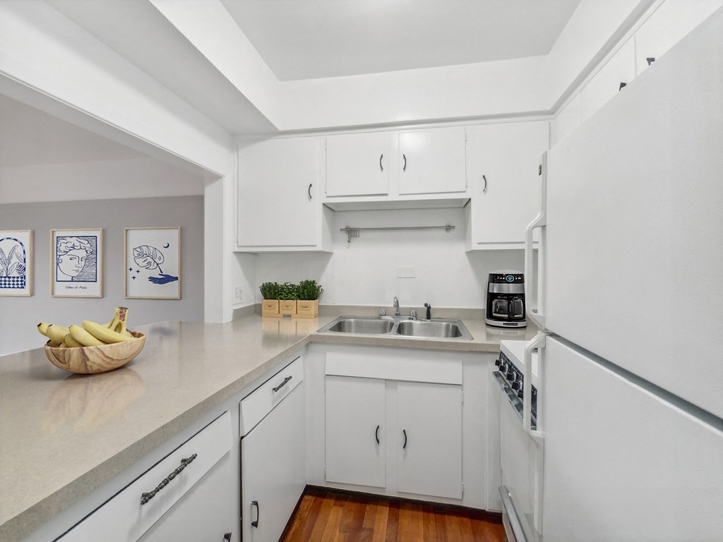 a kitchen with white cabinets and white appliances