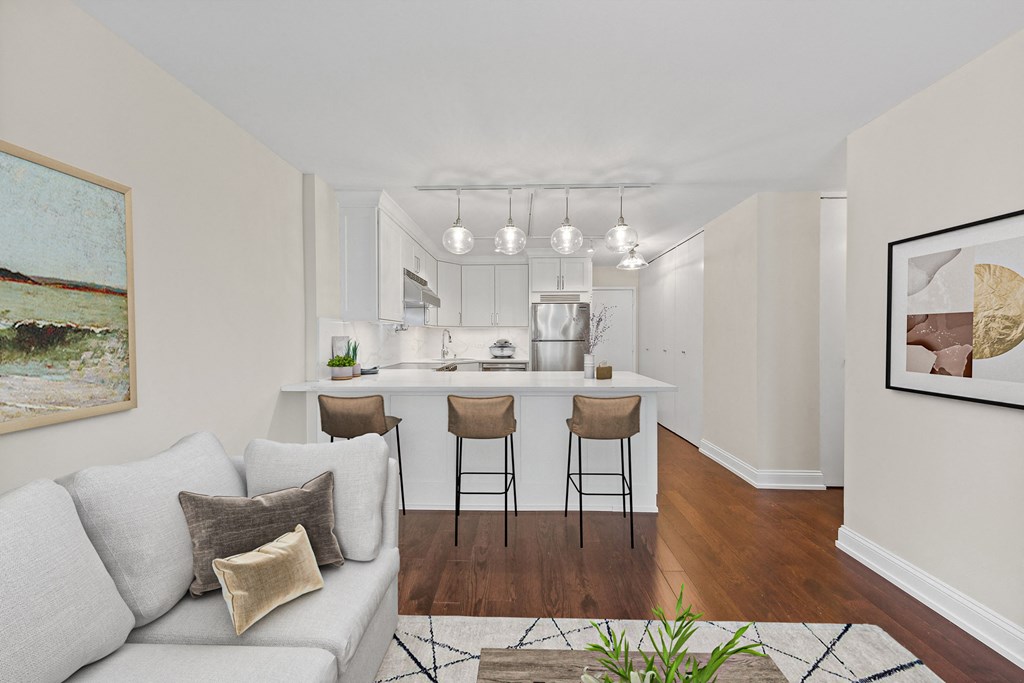 a living room with a couch and a kitchen with a bar