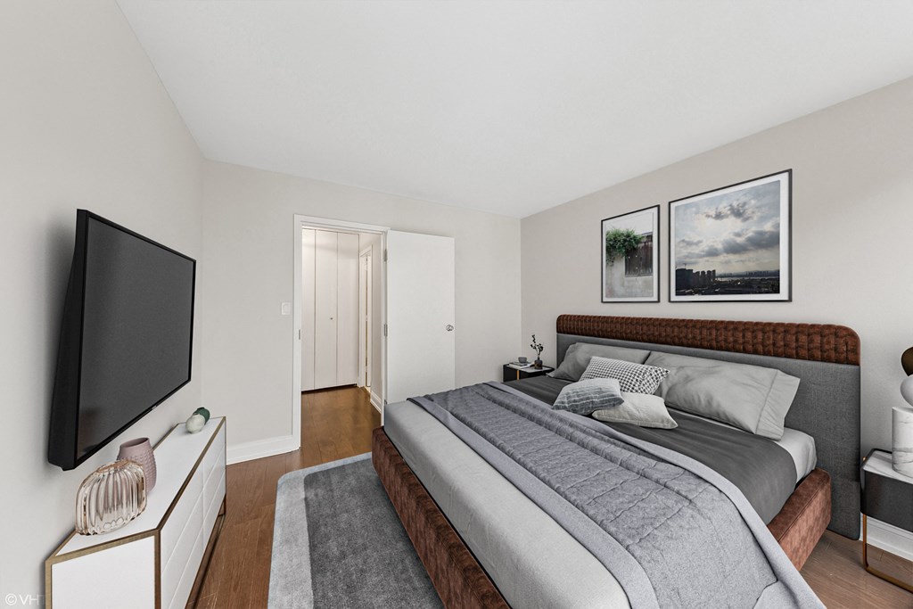 a bedroom with a bed and a tv on the wall