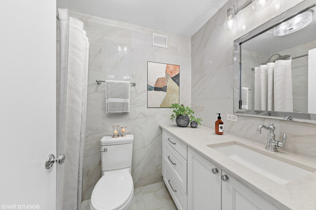 a bathroom with a sink toilet and a mirror