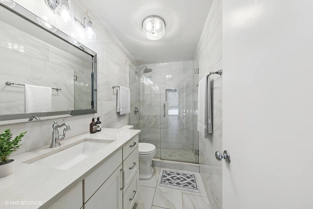 a white bathroom with a shower and a sink