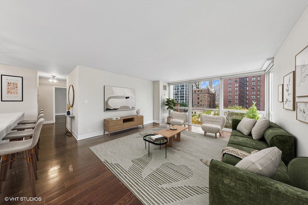 a living room with a green couch and a large window