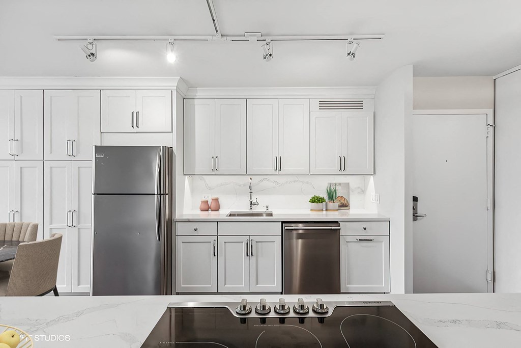 a kitchen with white cabinets and a stainless steel refrigerator