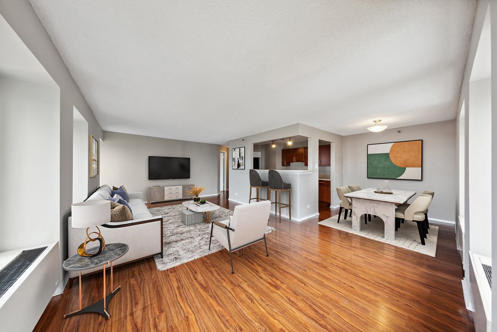 the living room and dining room of a house with wood floors and white furniture