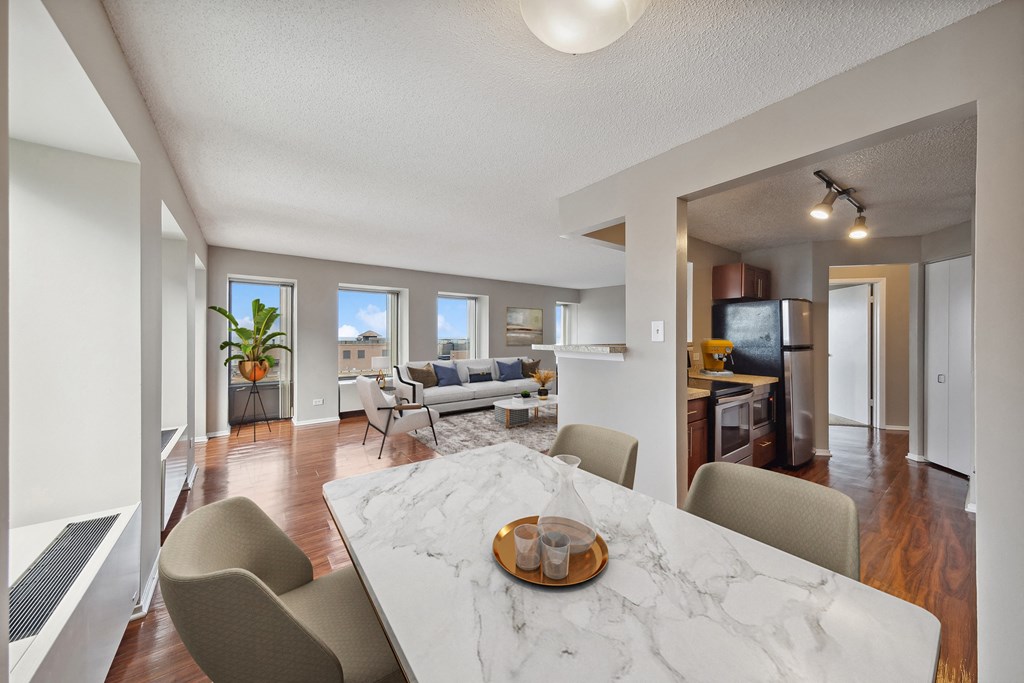 an open living room and dining room with a marble table and chairs
