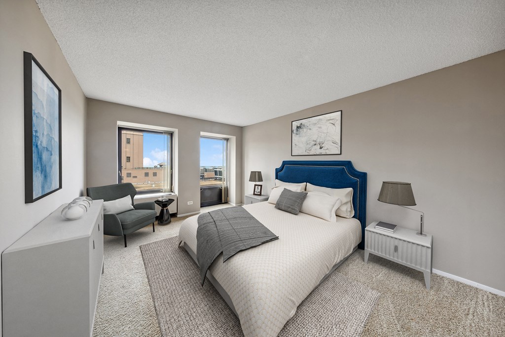 a master bedroom with a bed and a chair and a window