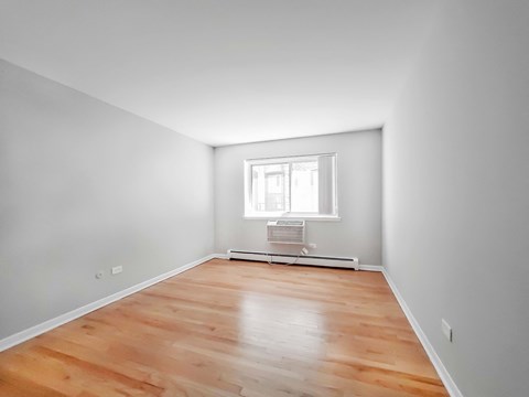 a bedroom with grey walls and a wooden floor