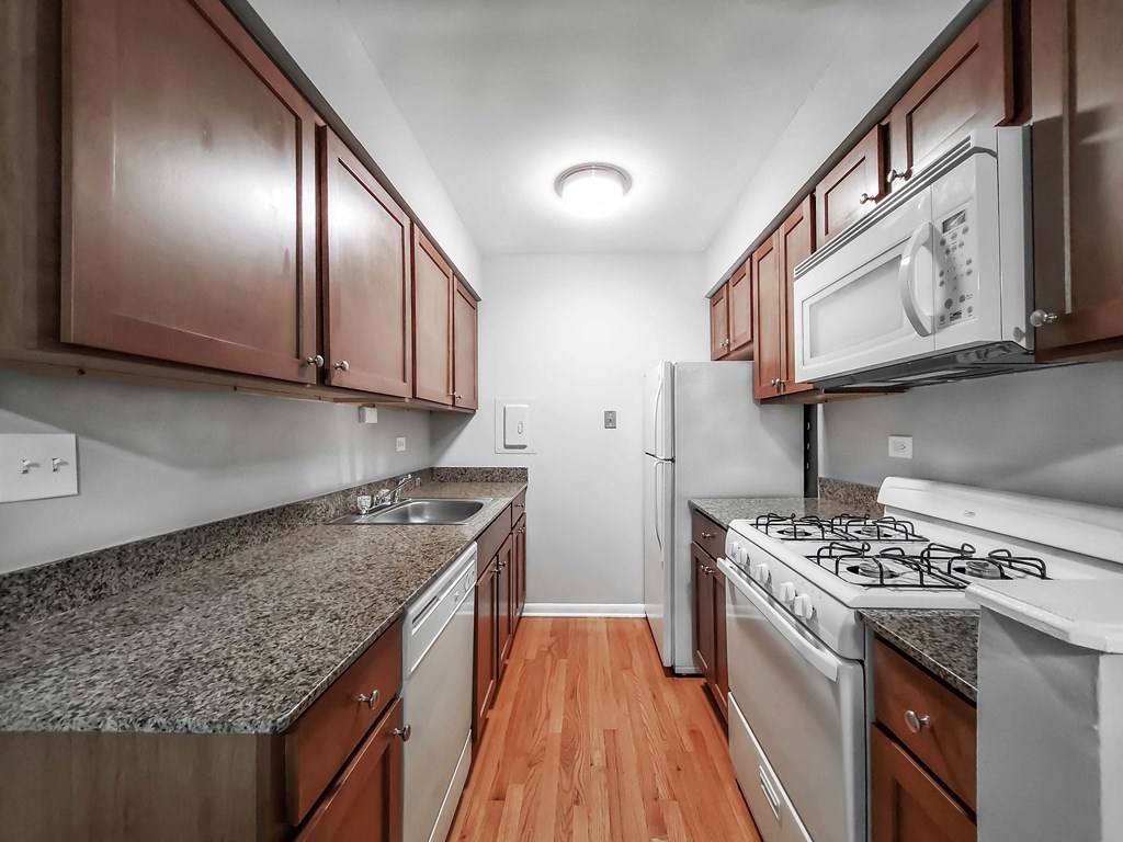a kitchen with granite countertops and wooden cabinets