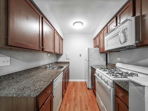 a kitchen with granite countertops and wooden cabinets