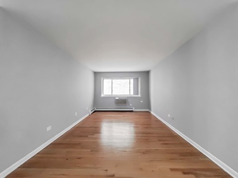 a bedroom with gray walls and a wood floor