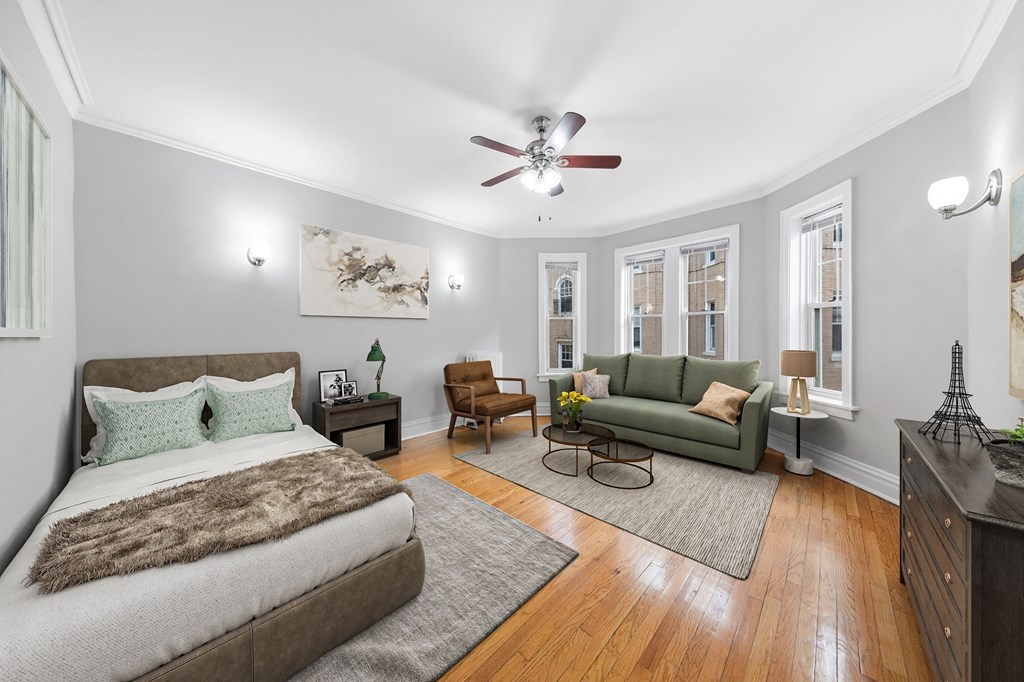 a bedroom with a bed and a couch and a ceiling fan