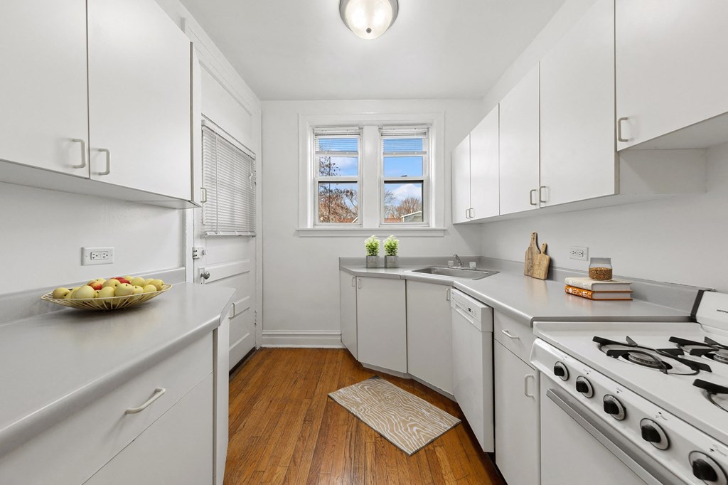 a kitchen with white cabinets and a stove and a window
