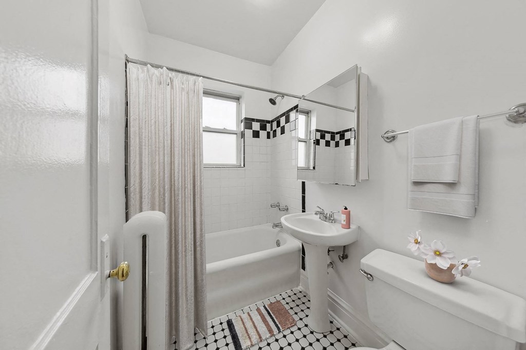 a white bathroom with a shower and a sink