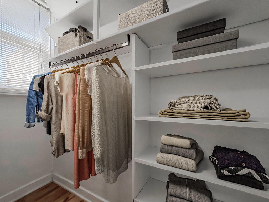 a closet with shelves and shelves of clothes and folded towels