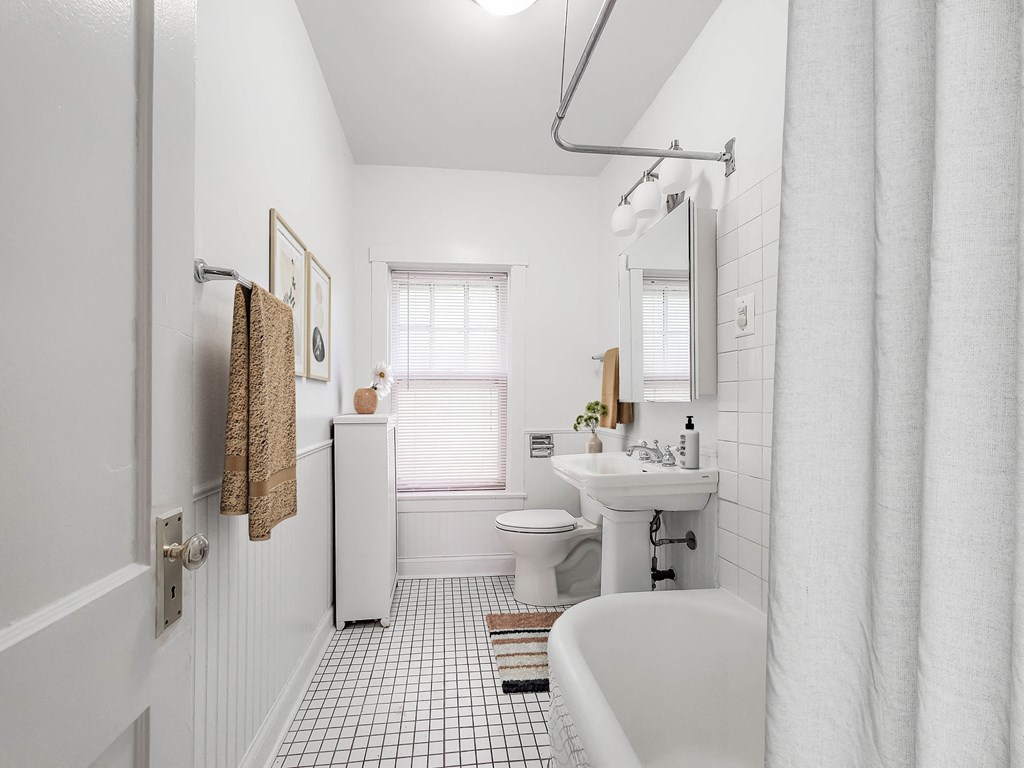 a white bathroom with a sink toilet and tub