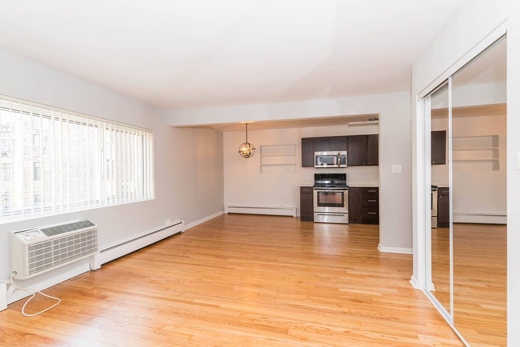 a living room with hardwood floors and a large window