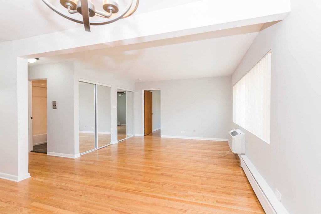 a living room with white walls and hardwood floors