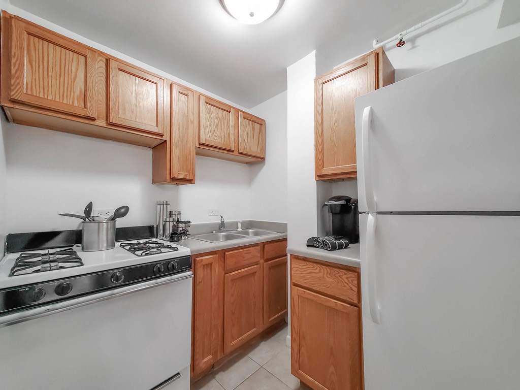 a kitchen with white appliances and wooden cabinets
