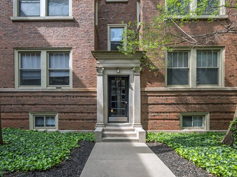 Brick entryway with steps and black door at Park Shores Apartments in Buena Park, Chicago.