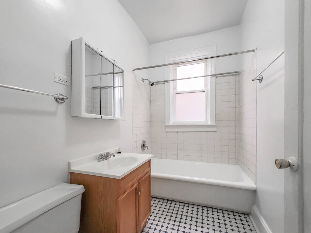 a bathroom with white walls and a black and white tiled floor