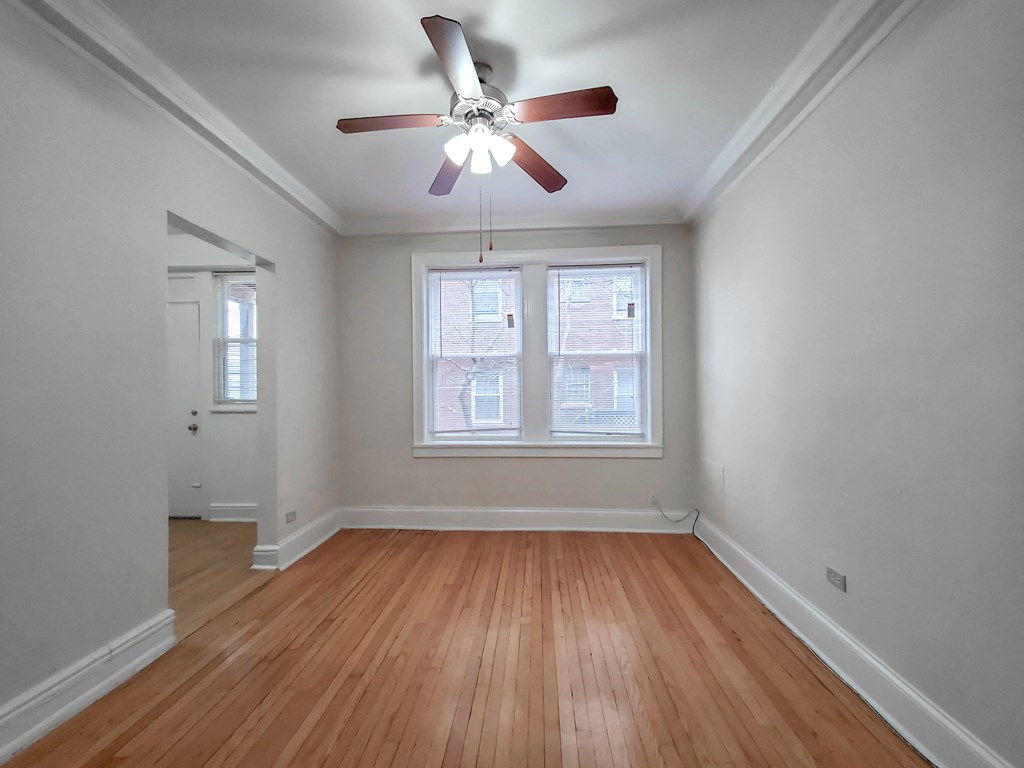 a bedroom with a ceiling fan and two windows