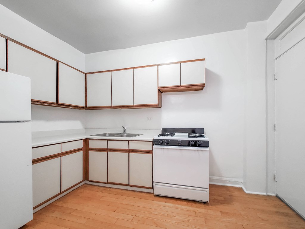a kitchen with white cabinetry and a wooden floor