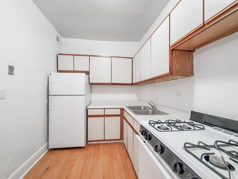 a kitchen with white cabinets and a stove and a refrigerator