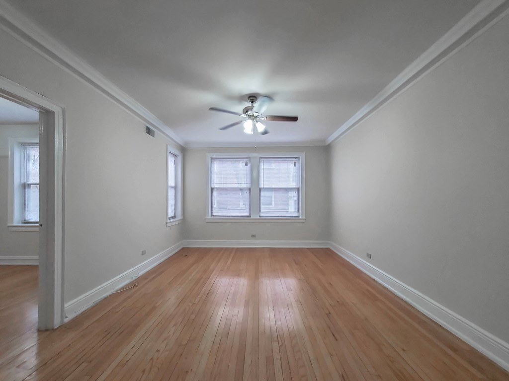 a bedroom with hardwood floors and a ceiling fan