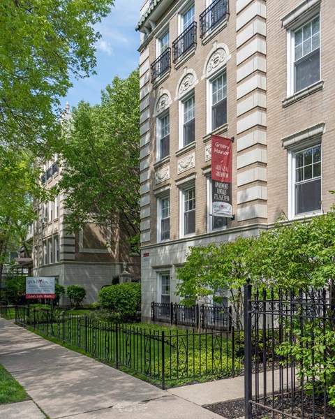 Green Manor brick apartment facade with landscaped front yard and banner for Apartments in Ravenswood Chicago.