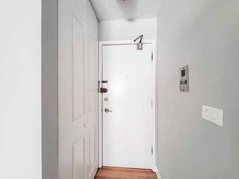 a white door in a room with a wooden floor and grey walls