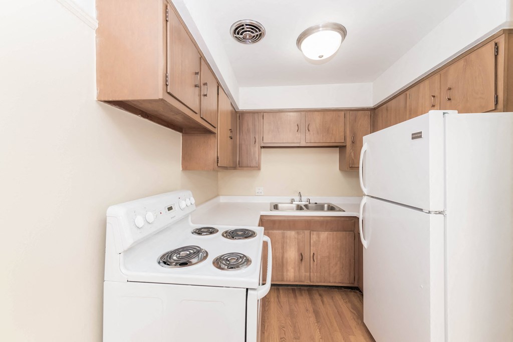 a kitchen with white appliances and wooden cabinets