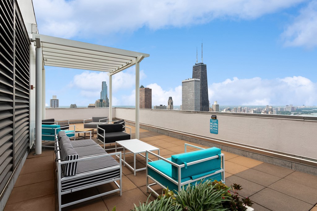 a roof top lounge with a view of the chicago skyline
