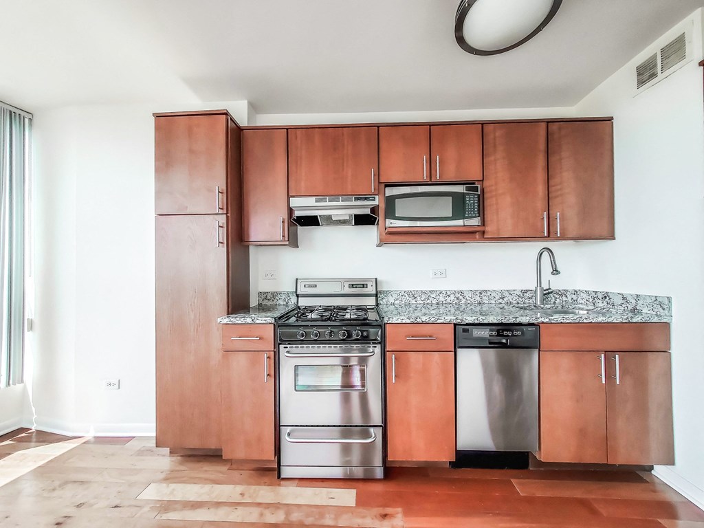 a kitchen with wooden cabinets and stainless steel appliances