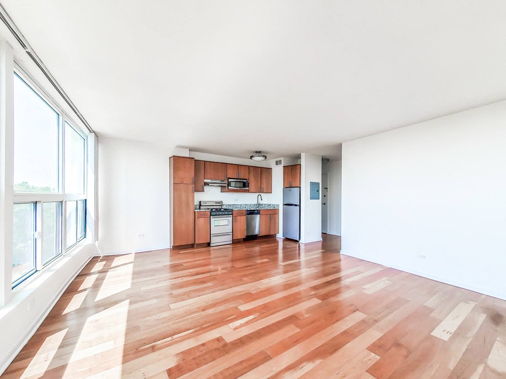 a living area with hardwood floors and a large window