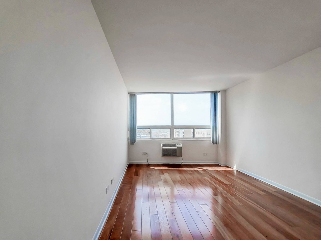 an empty room with white walls and a large window with blue shutters