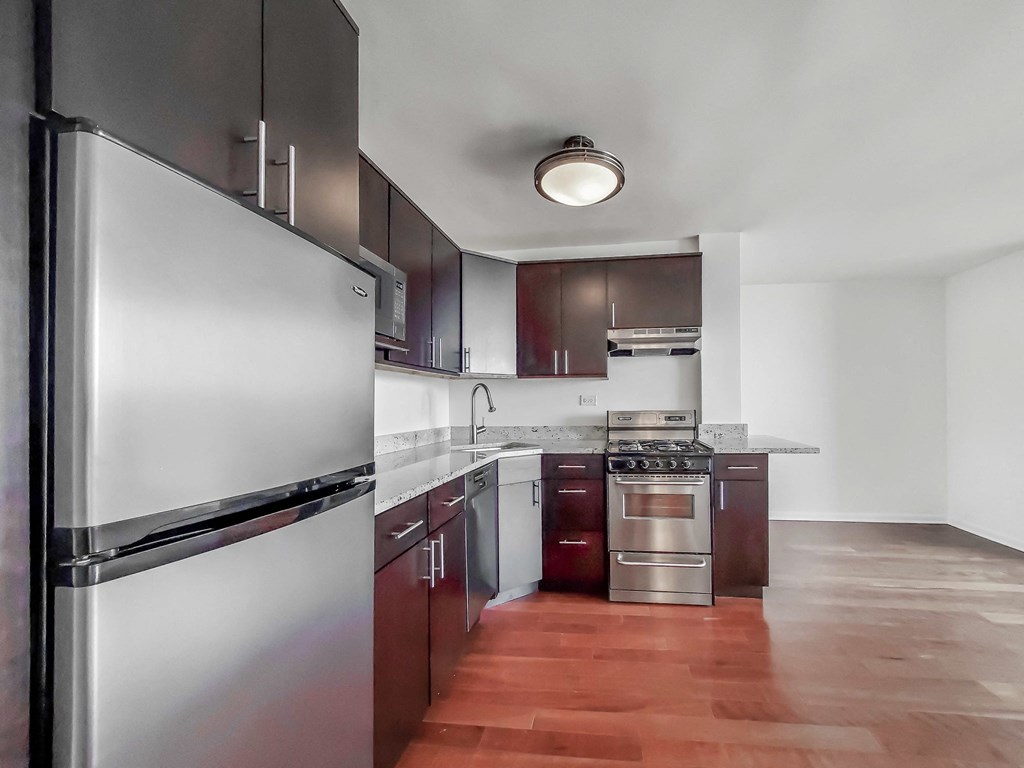 a kitchen with dark wood cabinets and stainless steel appliances