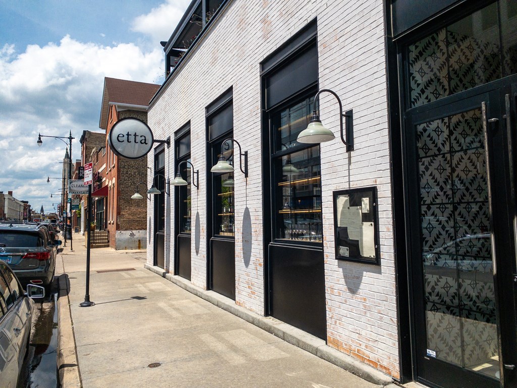 a white brick building with black windows and doors