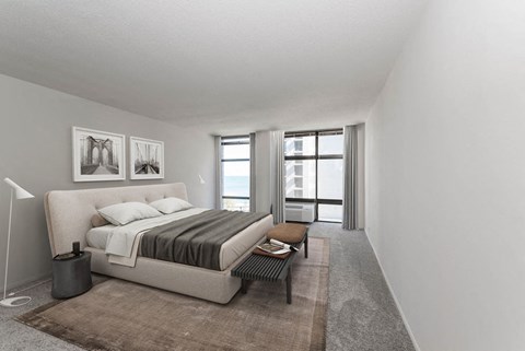 Bright bedroom with upholstered bed, bench and large windows with lake view at 65 East Scott apartments, Gold Coast Chicago.