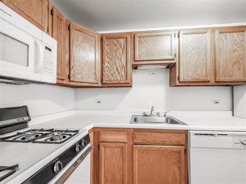 a kitchen with white appliances and wooden cabinets